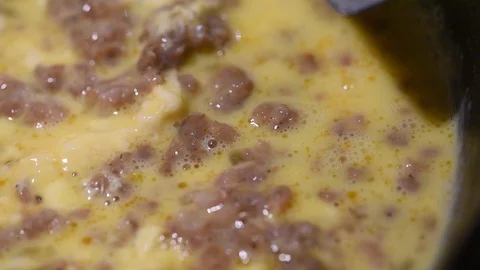 Cooking handheld close up sausage eggs on cast iron Stock Footage 93969863
