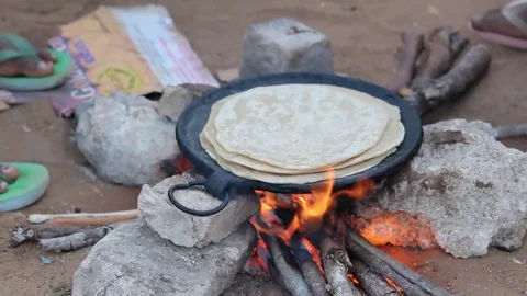 Cooking Indian bread over the fire Stock Footage 69264389