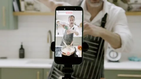 Cooking Influencer Filming Cooking Tutorial on Smartphone in Modern Kitchen Stock Footage 328761261