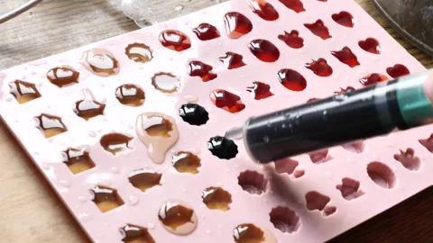 Cooking jelly in small molds in shape of different bears made of jelly bears. 動画素材 244877126