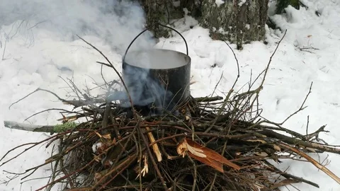 Cooking in a kettle on a fire in the winter. Stock Footage 72972953
