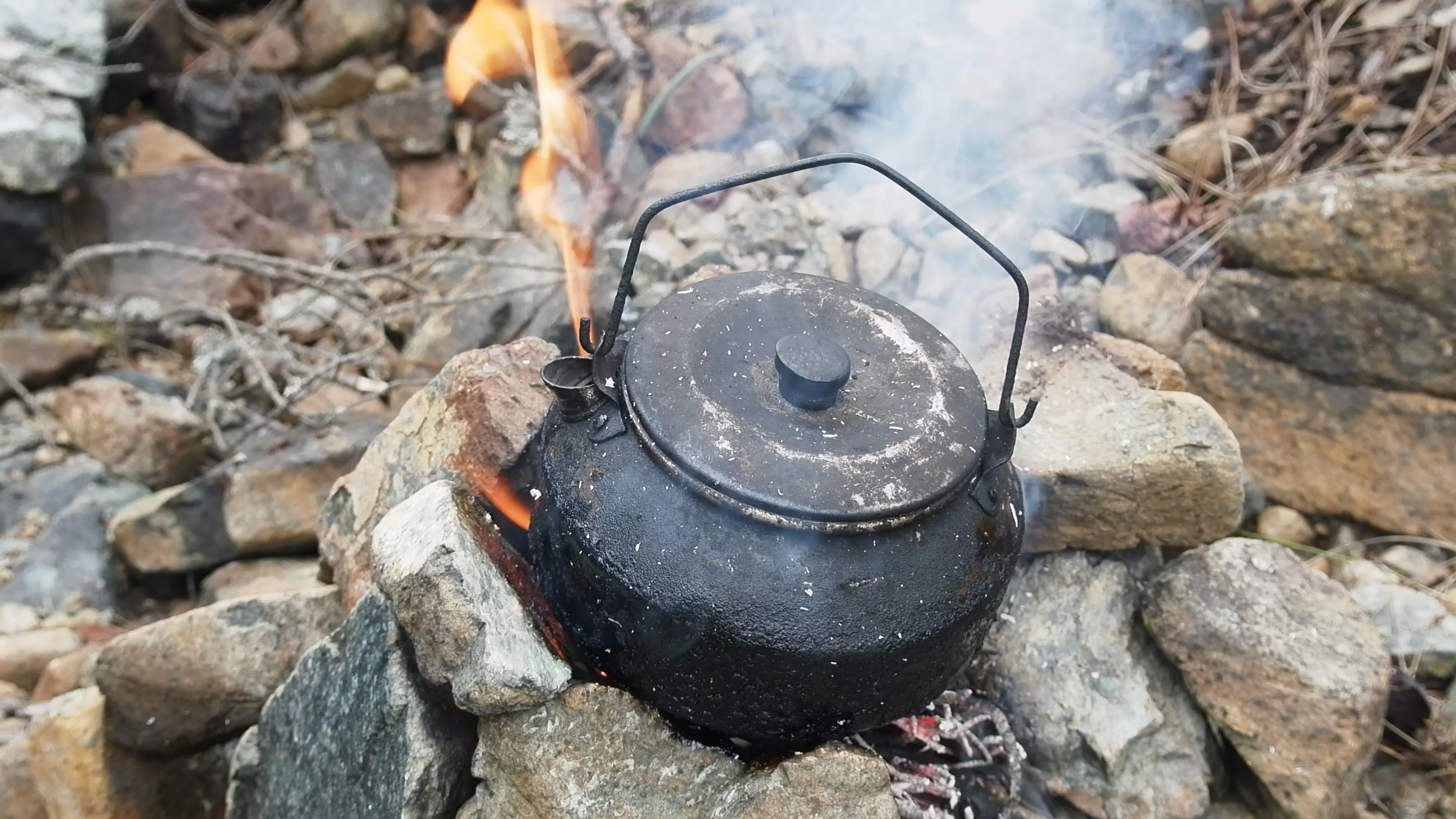 Kettle boiling over an open flame while camping, Atlin, British