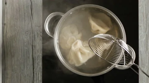 Cooking khinkali in a pot. Taking out the dumplings. View from above. Stock Footage 147870632