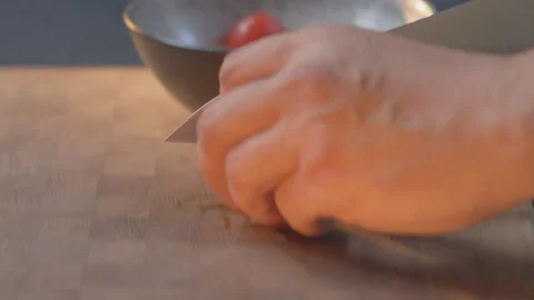 Cooking in the kitchen. Cutting cherry tomatoes on sclices on the catting board Stock Footage 129608345