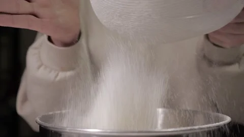 Cooking in the kitchen. sifting flour and dry ingredients through a sieve in bow Stock Footage 218602300