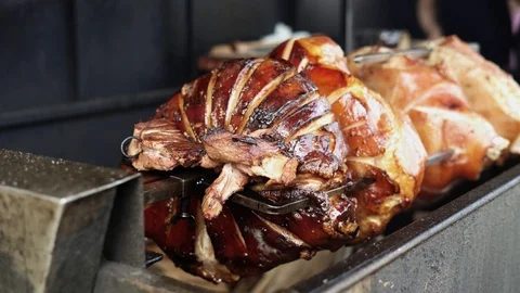 Cooking large pieces of meat on a spit of a street barbecue. Stock Footage 125902170