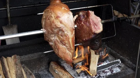 Cooking large pieces of meat on a spit of a street barbecue. Stock Footage 125902218