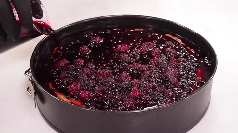 Cooking lemon raspberry cheesecake. Pouring lemon raspberry on the cheesecake. Stock Footage 141699480