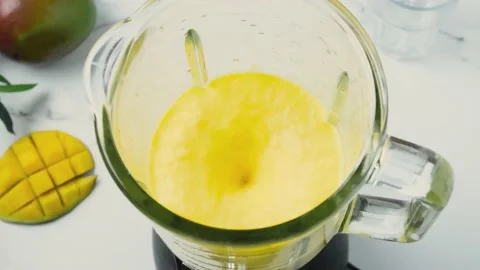 Cooking mango smoothie or milkshake in blender with splashes Video stock 196627404