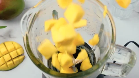 Cooking mango smoothie or milkshake in blender. Ripe fruits falling in blender Stock Footage 251010722