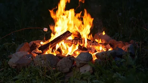 Cooking marshmallow over the camp fire in UHD Видео 112541512