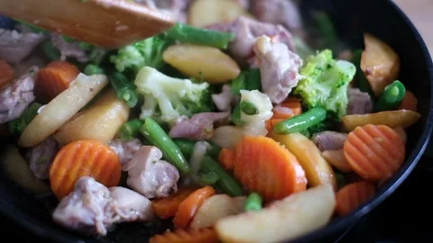 Cooking Meat and Mixed Vegetables in a Frying Pan 4K Stock Footage 345424106