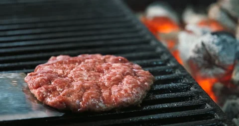 Cooking meat cotlet grill for burger on coals, opened fire. Beef or pork grilled Stock Footage 135796148