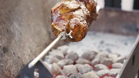 Cooking meat on a grill using charcoal and rotating the spit over the hot coals 스톡 동영상 332053955