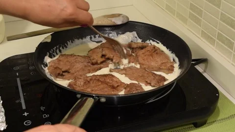 Cooking meat in a pan on an induction plate Stock Footage 78709235