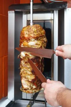 Cooking meat for shawarma. Middle Eastern dish prepared on the grill. Stock Photos