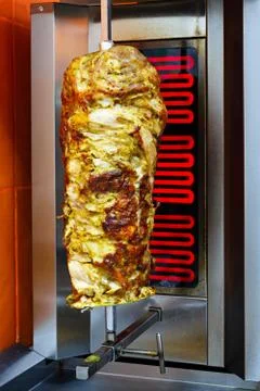 Cooking meat for shawarma. Middle Eastern dish prepared on the grill. Stock Photos