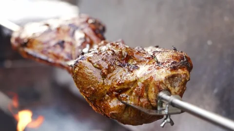 Cooking meat on a spit over an open flame 스톡 동영상 332053879