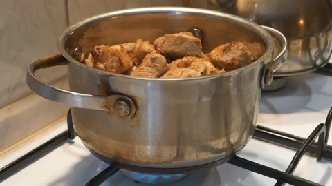Cooking. Meat is stewing. There is a pot of meat on the gas stove, zoom-in video Video stock 318035397
