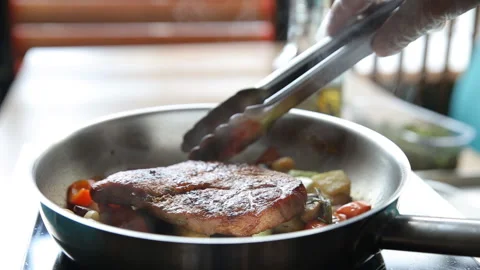Cooking meat with vegetables in a pan Stock Footage 107870378