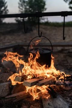 Cooking in a metal pot on a fire while camping, close up of organ in flames Stock Photos