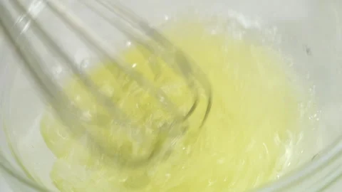 Cooking mixing sugar with egg white in glass bowl using metal whisk. Video stock 313127637