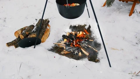 Cooking mulled wine on the bonfire in the winter forest. Vídeos de archivo 100012742