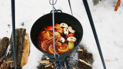 Cooking mulled wine on the bonfire in the winter forest. Vídeos de archivo 100012910