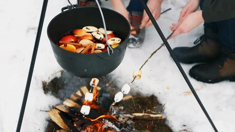 Cooking mulled wine on the bonfire in the winter forest. Stockbeeldmateriaal 100013177