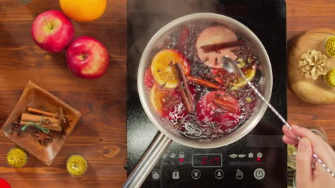 Cooking mulled wine top view, gluhwein recipe. Boiling red hot wine with apples Stock Footage 165767979