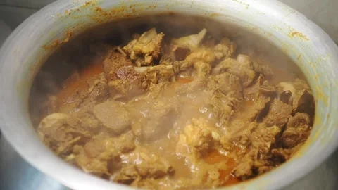 Cooking mutton meat in a large pot on the stove for a meal Stock Footage 337125704