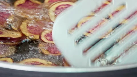Cooking native Peruvian purple potato chips in hot oil using a metal spatula. 動画素材 339078309