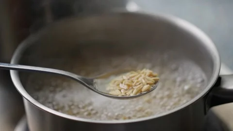 Cooking oats in boiling water is a quick and delightful way to prepare a warm Video stock 304684684