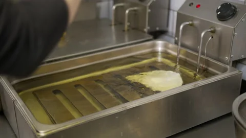 Cooking oil boiling and bubbling in fryer for deep frying dishes in a Stock Footage 144183532