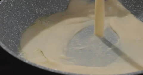 Cooking omelet on a frying pan. Chef pours mixed or whisked eggs on a pan. Close Stock Footage 250811280