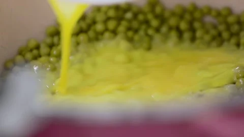 Cooking omelet with green peas Stock Footage 243496014