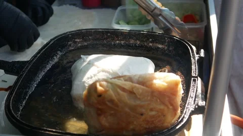 Cooking or frying beef spring rolls in a frying pan Stock Footage 309725575