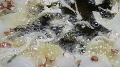Cooking or making peanut crackers in a frying pan with hot oil Stock Footage 304773114