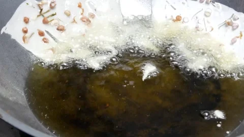 Cooking or making peanut crackers in a frying pan with hot oil Stock Footage 304773137