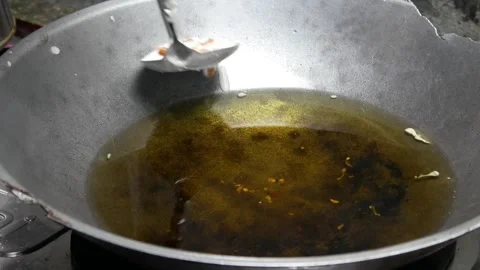 Cooking or making peanut crackers in a frying pan with hot oil Stock Footage 304773167