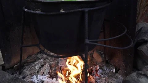 Cooking an oriental dish in a cauldron on fire Stock Footage 238744711