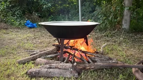 Cooking Over Open Fire in a Large Cauldron with Smoke and Flames. Stock Footage 296670157