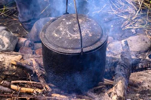 Cooking over an open fire in the wilds of Russia amid swirling smoke Stock Photos