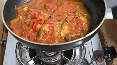 Cooking pabda fish in tomato, onion, oil on fry-pen. Slow motion video Stock Footage 209134140