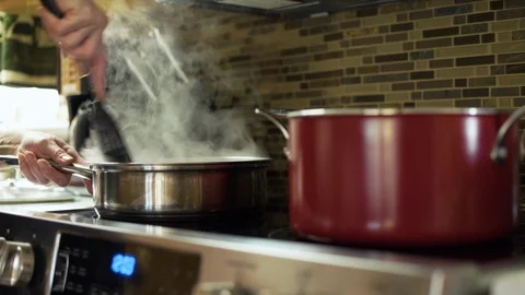 Cooking in a pan over a stove Stock Footage