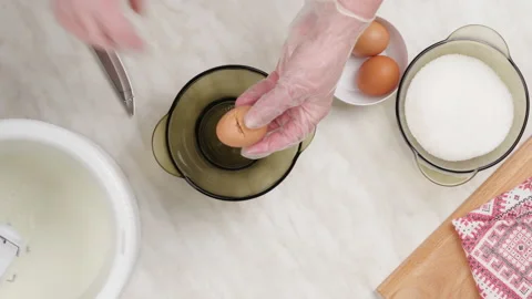 Cooking pancake dough. We break the chicken eggs into a glass bowl. top view Stock Footage 148931205