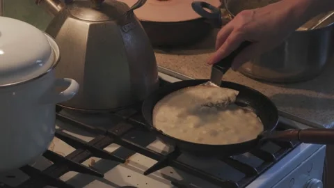 Cooking pancakes in a dark kitchen Stock Footage 233921944