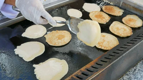 Cooking pancakes on a large baking sheet in a restaurant Stock Footage 100843770