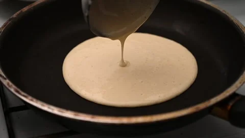 Cooking pancakes step by step. The dough is poured into the pan from the ladle Stock Footage 234405887