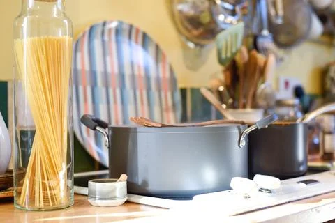 Cooking pasta in a home kitchen interior the pan has boiling water to cook .. Stock Photos